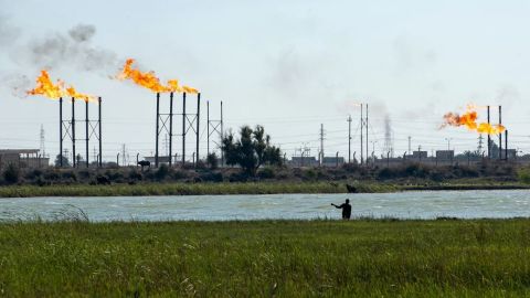 Un hombre iraquí cría sus búfalos de agua en el río Shatt al-Arab junto al campo petrolífero de Nahr Bin Omar y a sus instalaciones cerca de la ciudad portuaria de Basora, en el sur de Iraq, el 4 de abril de 2023. Crédito: Hussein Faleh/AFP/Getty Images