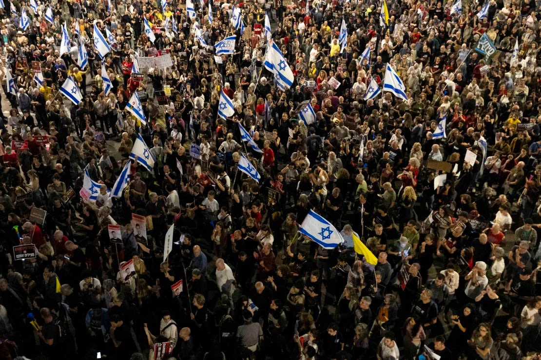 Los manifestantes sostienen banderas y carteles durante una manifestación que pide un acuerdo de rehenes con Hamas y contra Netanyahu y su gobierno, en Tel Aviv, Israel, el 11 de mayo. Crédito: Amir Levy/Getty Images.