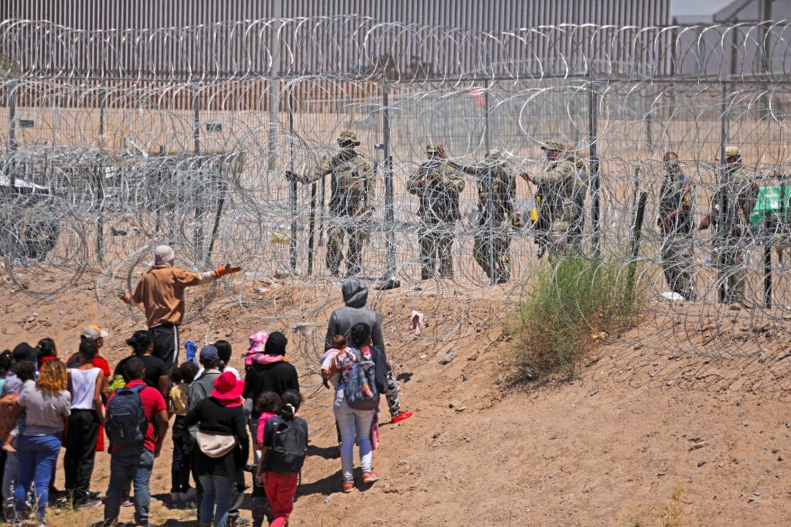 Migrantes que intentan ingresar a Estados Unidos a través de una cerca de alambre de púas instalada a lo largo del Río Grande son expulsados con disparos de gas pimienta por agentes de la Guardia Nacional de Texas en la frontera con Ciudad Juárez, estado de Chihuahua, México, el 13 de mayo de 2024.