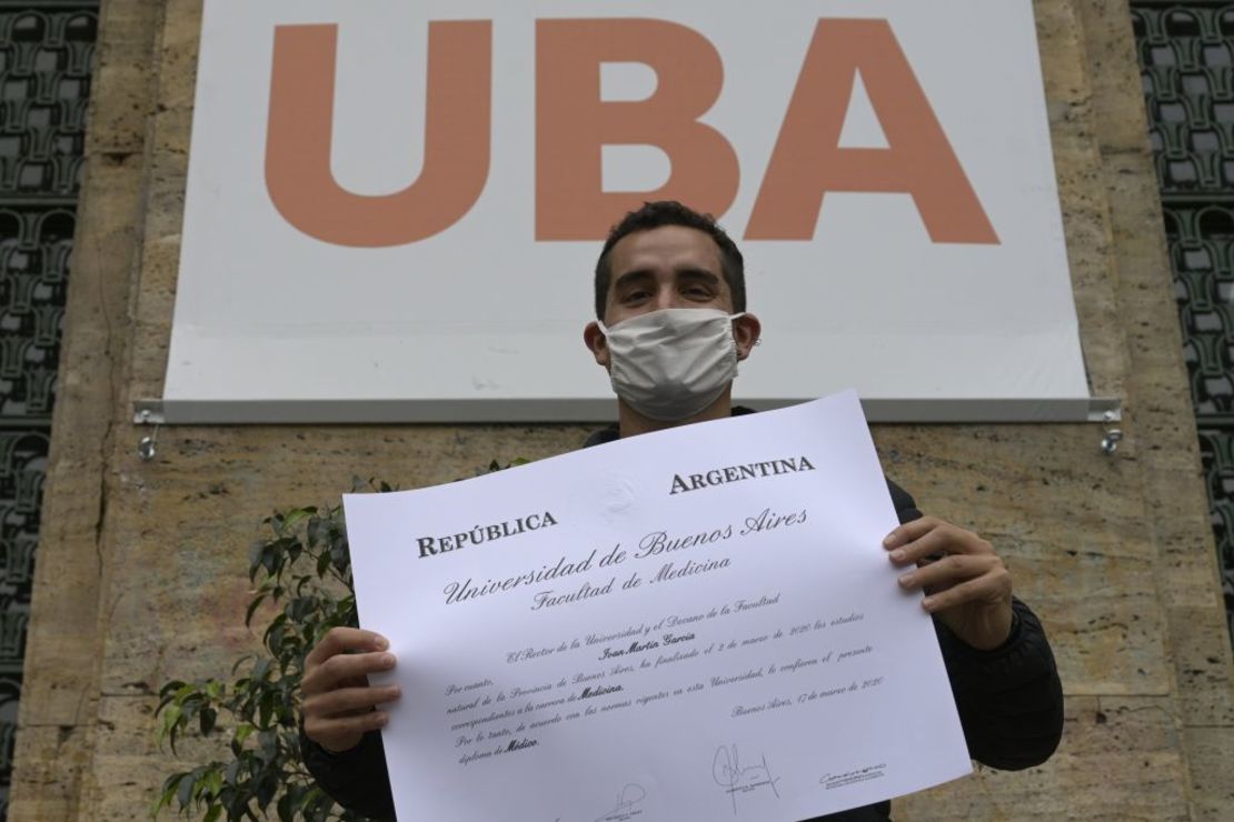 Un médico recién graduado posa con su diploma frente a la Facultad de Medicina de la Universidad de Buenos Aires el 22 de abril. 2020.