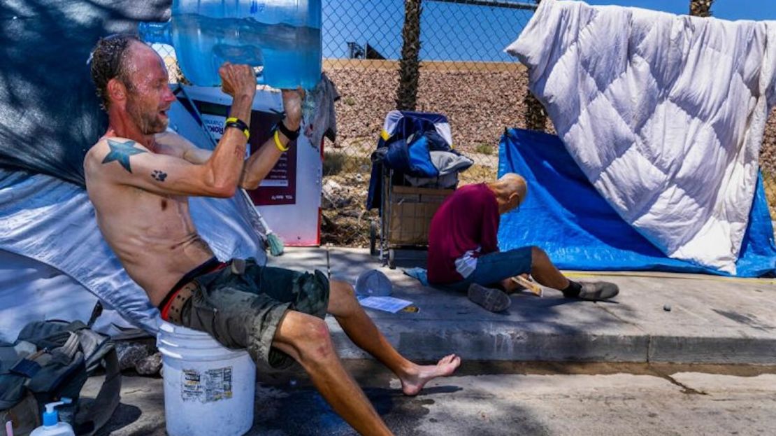 Milton John Scott III, una persona sin hogar, se echa una jarra de agua en la cabeza para escapar del calor y asearse en su refugio de Las Vegas, Nevada, el 5 de junio de 2024.