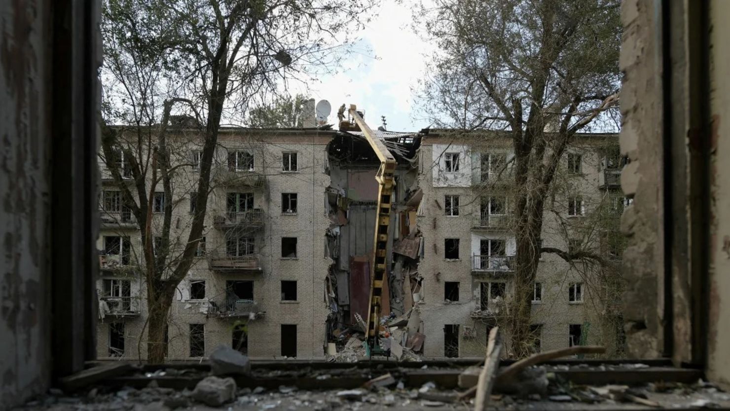 Los rescatistas limpian los escombros de un edificio residencial destruido tras un ataque con misiles en Luhansk.