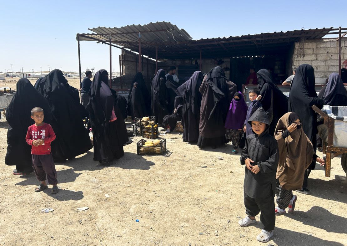 Mujeres y niños se reúnen en un pequeño mercado en el punto de entrada a Al-Hol, un campo de detención para los familiares de los combatientes de ISIS en el noreste de Siria. Crédito: Mike Pratt/CNN