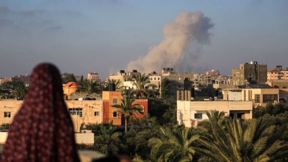 Una mujer palestina observa el humo que sale tras un ataque israelí al sur de la Ciudad de Gaza, en la ciudad de al-Zawaida, en el centro de Gaza, el 11 de junio de 2024. Crédito: Eyad Baba/AFP/Getty Images