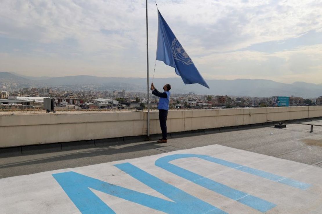 Un empleado del Organismo de Obras Públicas y Socorro de las Naciones Unidas (OOPS) baja la bandera de la ONU en el tejado de las oficinas regionales de la organización en Beirut, capital libanesa, el 13 de noviembre de 2023.