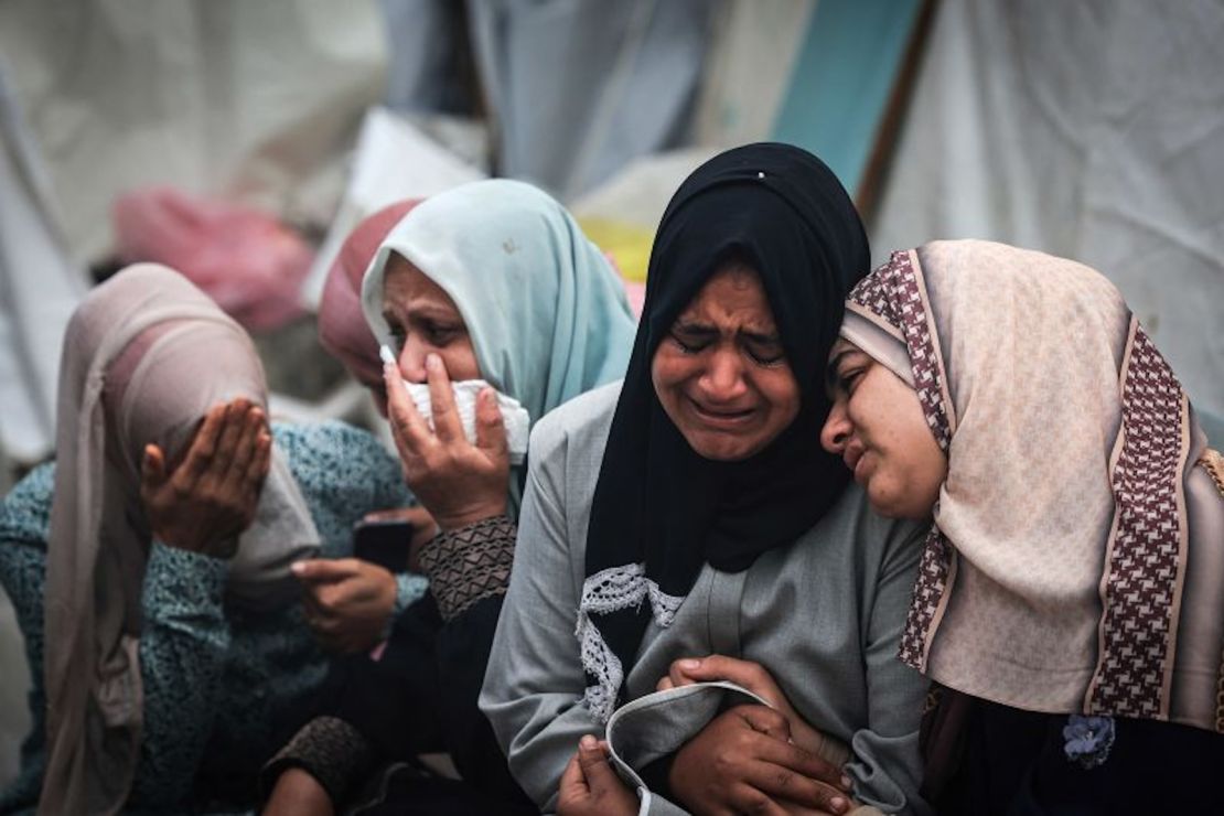 Palestinos lloran a sus familiares, muertos en un ataque israelí nocturno sobre el campo de refugiados de Al-Maghazi, durante un funeral masivo en el hospital Al-Aqsa en Gaza el 25 de diciembre de 2023.