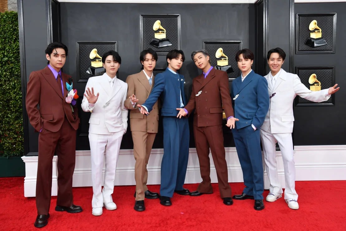 Los miembros de BTS con trajes Louis Vuitton de lana y cachemira de colores coordinados con alfileres florales en la 64ª edición anual de los premios Grammy el 3 de abril de 2022. (Foto: Angela Weiss/AFP/Getty Images/File).