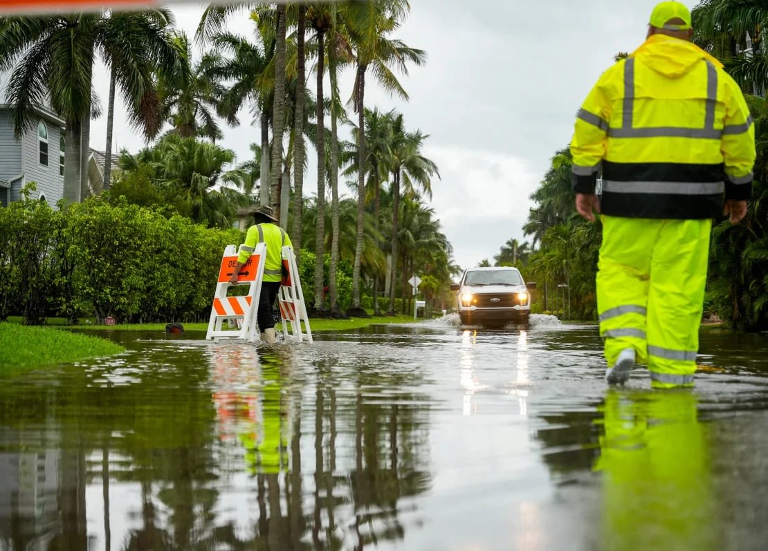 Los empleados de aguas pluviales de la ciudad de Naples instalaron barricadas para evitar que las personas conduzcan a lo largo de una sección inundada de Gulf Shore Boulevard South mientras llueve en Naples, Florida, el martes Jonah Hinebaugh/Naples Daily News/USA Today Network