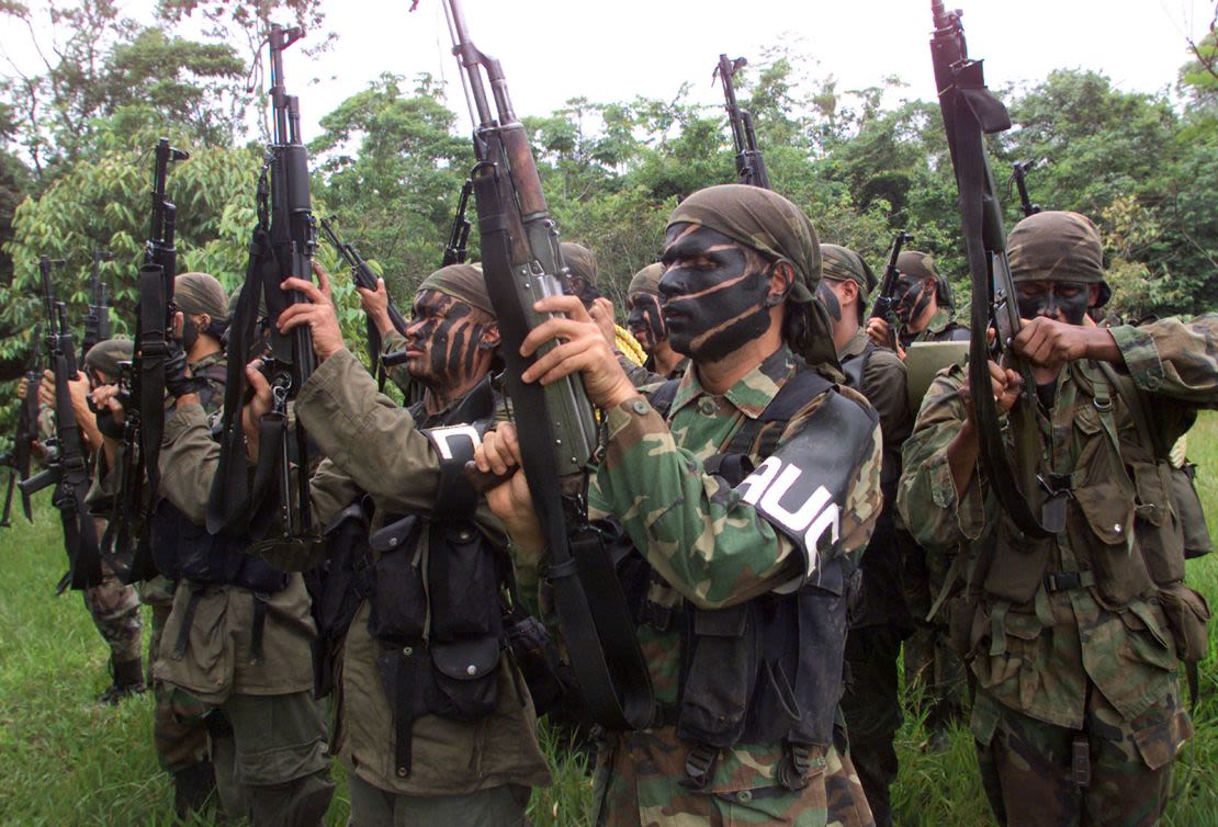 En esta foto de archivo de mayo de 2000, miembros de las Autodefensas Unidas (AUC) blanden sus armas durante una sesión de entrenamiento en una zona rural de Puerto Asís, provincia de Putumayo, al sur de Colombia.