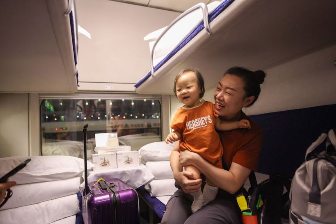 Una pasajera con un bebé sube al tren-cama de alta velocidad en Beijing para su viaje inaugural a la estación de Kowloon Oeste de Hong Kong.