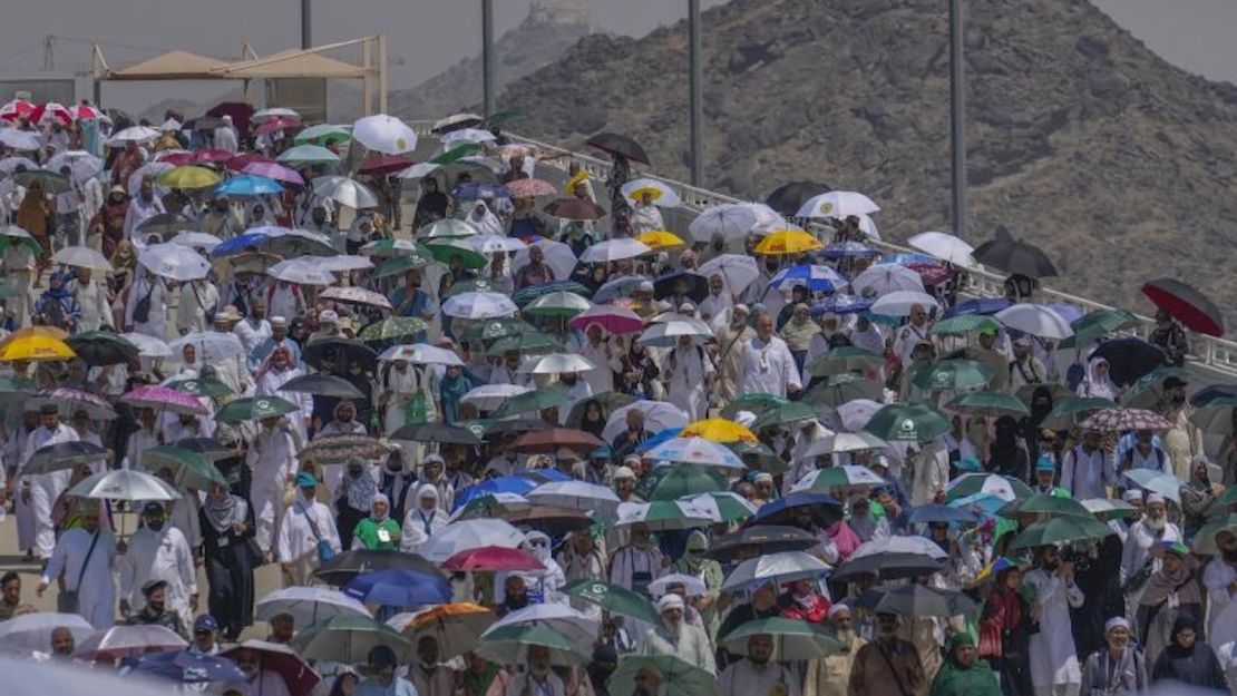 Peregrinos musulmanes usan paraguas para protegerse del sol mientras llegan para arrojar piedras a los pilares en la lapidación simbólica del diablo en Mina, cerca de la ciudad santa de La Meca, el 18 de junio de 2024.