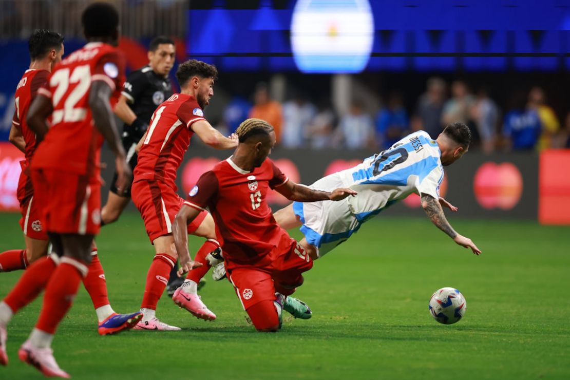 En esta foto Messi es abordado por Jonathan Osorio y Derek Cornelius de Canadá durante el partido