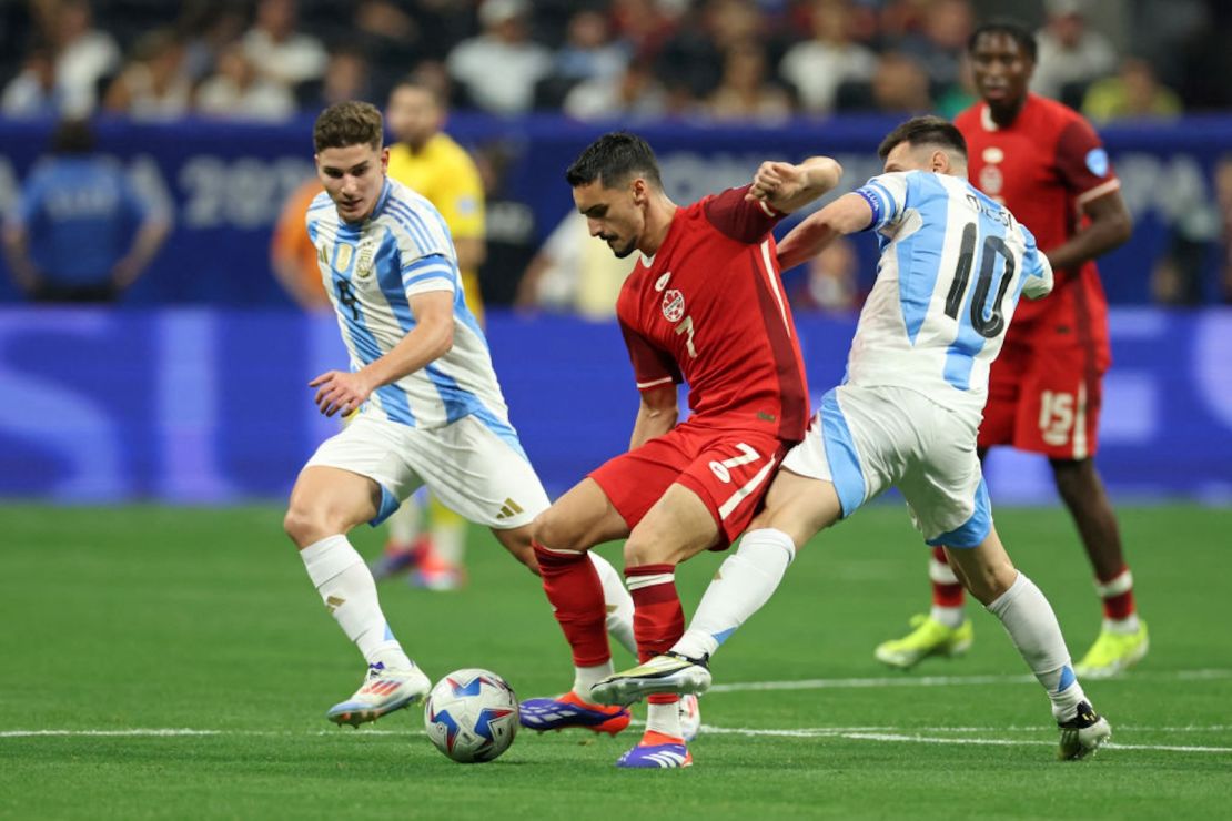 El centrocampista de Canadá #07 Stephen Eustaquio lucha por el balón con el delantero de Argentina Julian Alvarez y el delantero de Argentina #10 Lionel Messi.