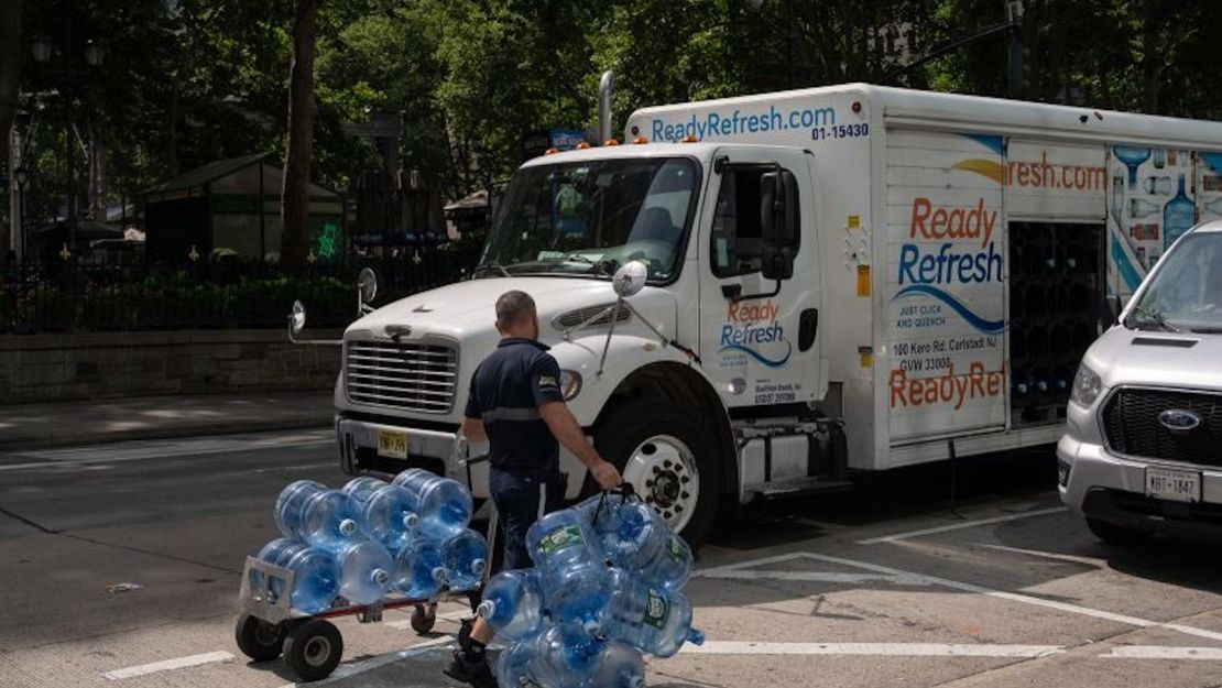 Un trabajador traslada garrafas de agua vacías a un camión durante las altas temperaturas en Nueva York, Estados Unidos, el jueves 20 de junio de 2024.