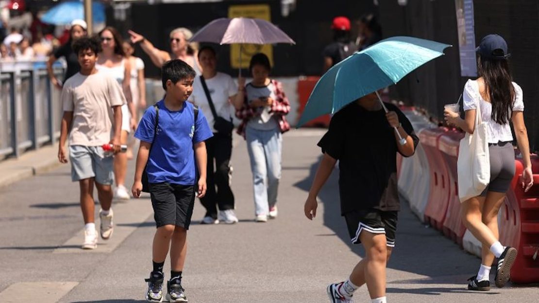 Gente camina por el Brooklyn Bridge Park en medio de una ola de calor el 19 de junio de 2024, en el barrio de Brooklyn en la ciudad de Nueva York.