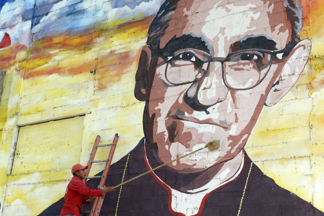 Un hombre limpia un mural dedicado a monseñor Romero.