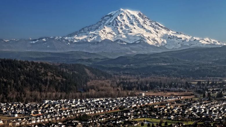 El monte Rainier, un volcán nevado, se cierne sobre el valle de Puyallup, cerca de Orting, Washington.
