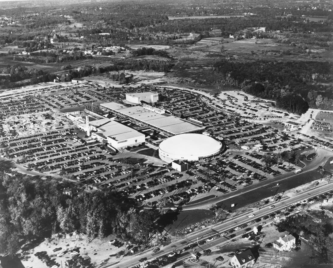 Vista aérea del Shoppers World y sus abarrotados estacionamientos en Framingham, Massachusetts, 1958. El centro comercial fue uno de los primeros centros comerciales suburbanos cerrados de Estados Unidos.