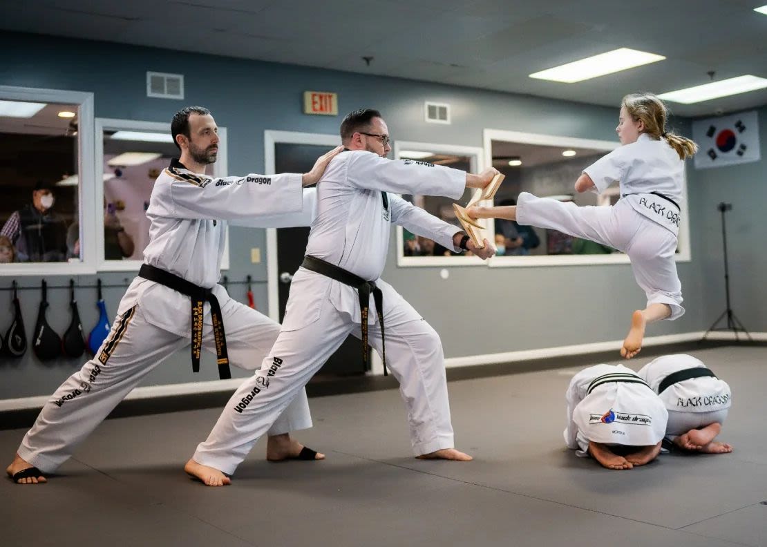 Aubrey Sauvie, que nació sin manos y con el pie izquierdo parcialmente amputado, rompe tablas para obtener su cinta negra de segundo grado en taekwondo.