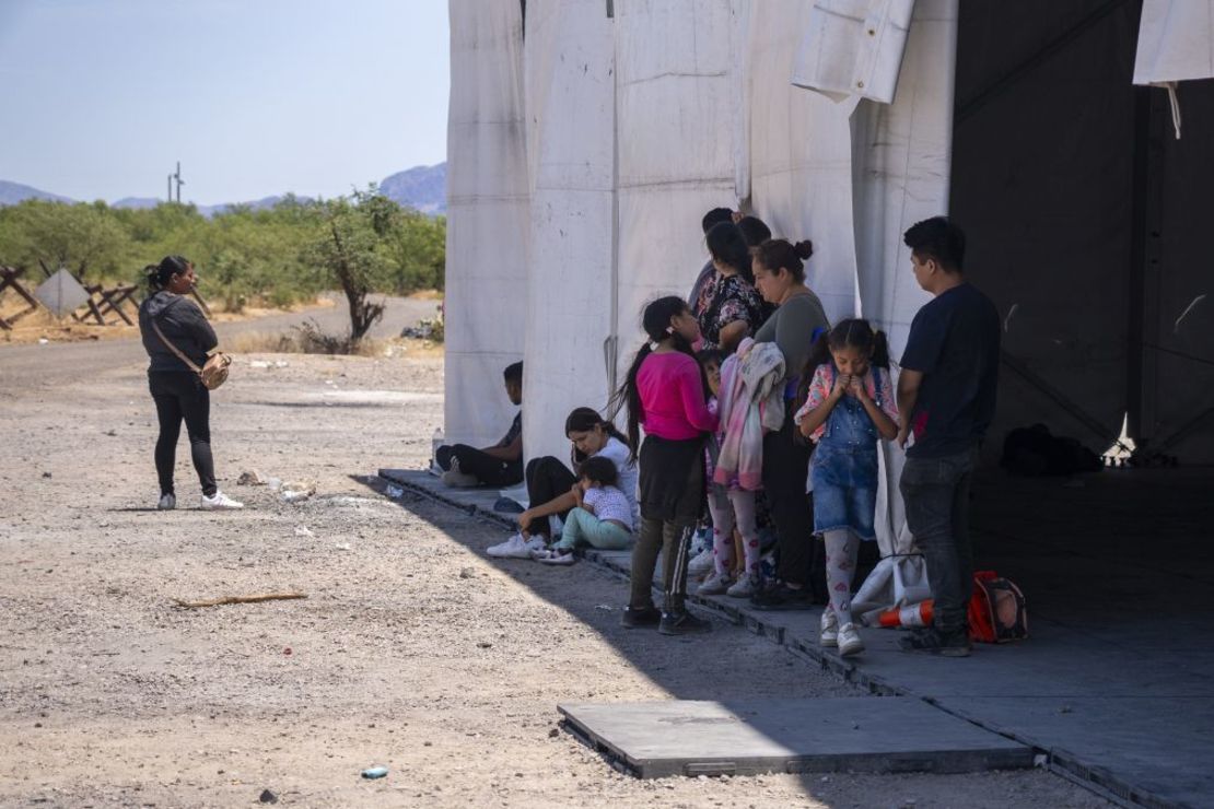 Varias personas esperan a ser acogidas por la Patrulla Fronteriza tras cruzar la frontera entre Estados Unidos y México cerca de la puerta de San Miguel, en la reserva Tohono O'odham, Arizona, en junio de 2024. Crédito: Evelio Contreras/CNN