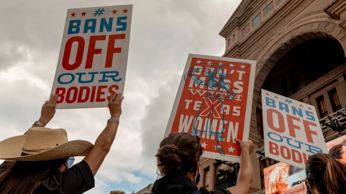 Manifestantes sostienen pancartas frente al Capitolio estatal de Texas durante una marcha de mujeres en Austin, Texas.