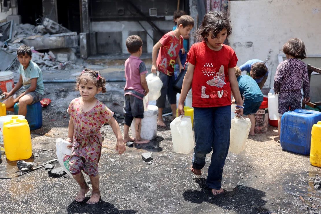 Niños palestinos llenan contenedores con agua en Jabalya, en el norte de Gaza, el 3 de junio. La ONU dice que al menos el 67% de las instalaciones de agua y saneamiento en el territorio devastado fueron destruidas o dañadas. Crédito: Omar Al Qatta/AFP/Getty Images.