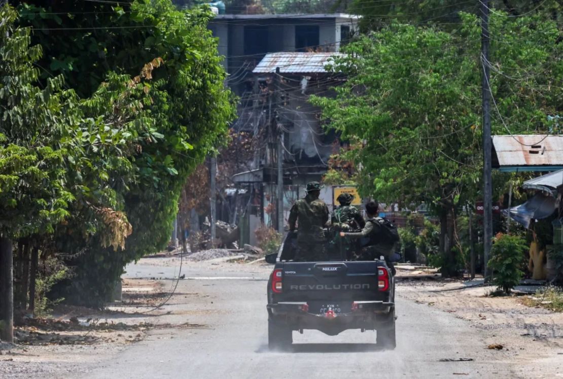 Soldados del Ejército de Liberación Nacional Karen (KNLA) patrullan en un vehículo, junto a una zona destruida por un ataque aéreo militar de Myanmar en Myawaddy, una ciudad fronteriza entre Tailandia y Myanmar, el 15 de abril de 2024.