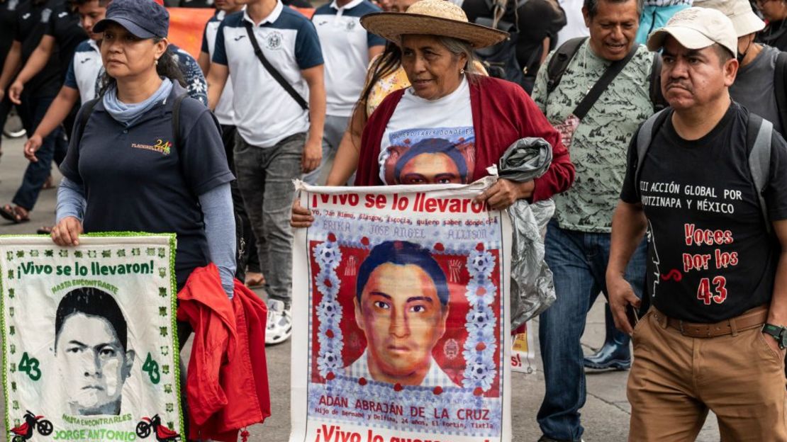 Padres y compañeros de clase sostienen fotografías de algunos de los estudiantes desaparecidos, durante una manifestación exigiendo al gobierno que aclare el paradero de los 43 estudiantes de la escuela normal rural de Ayotzinapa en el estado de Guerrero, en la Ciudad de México, el 26 de junio de 2024.