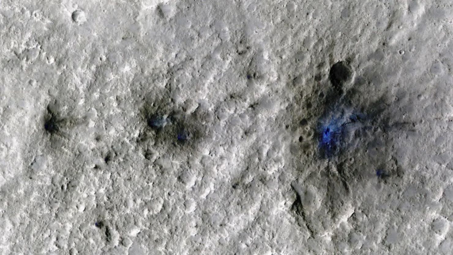 El impacto de un meteoroide en Marte formó cráteres marcianos, que se ven en azul, el 5 de septiembre de 2021. La misión InSight de la NASA detectó los impactos y la sonda Mars Reconnaissance Orbiter tomó imágenes de los cráteres. NASA/JPL-Caltech/Universidad de Arizona