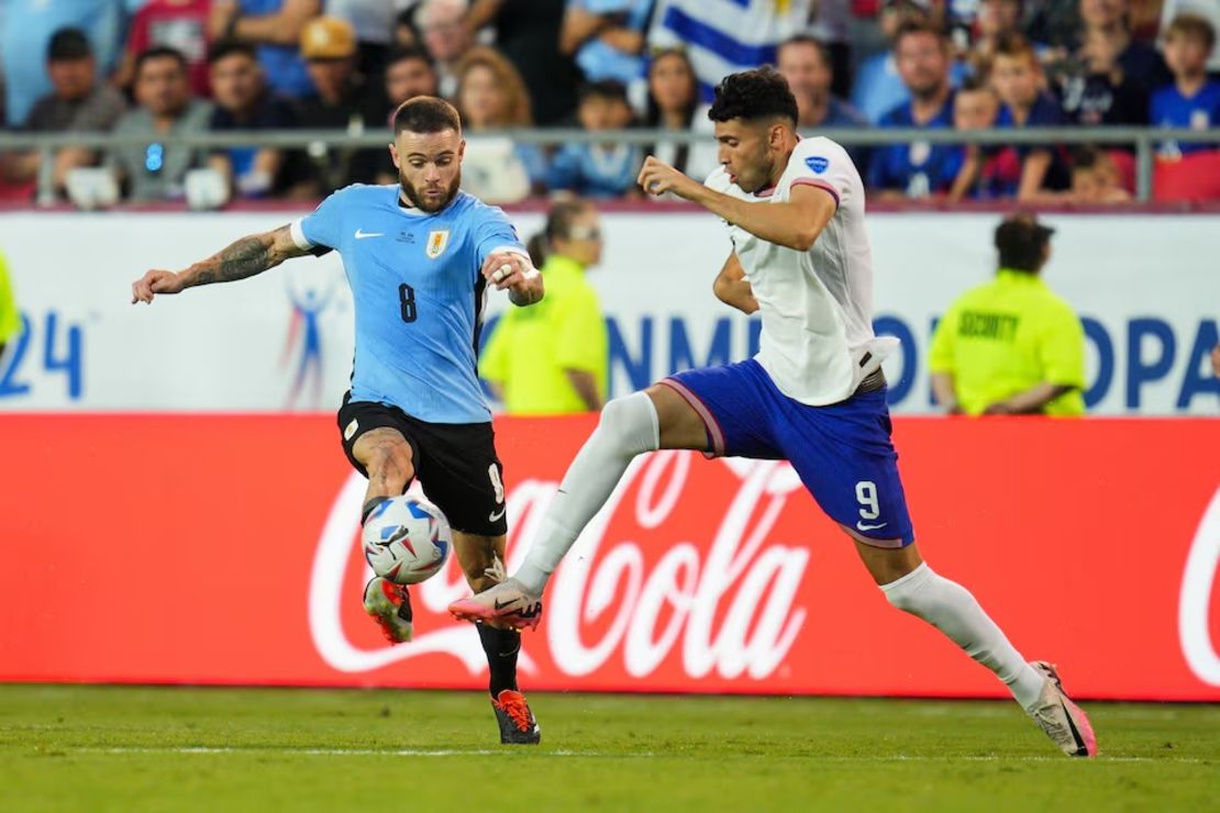 El delantero estadounidense Ricardo Pepi (9) y el mediocampista uruguayo Nahitan Nandez (8) luchan por el balón durante la primera mitad de un partido de la Copa América en el Arrowhead Stadium el 1 de julio de 2024.