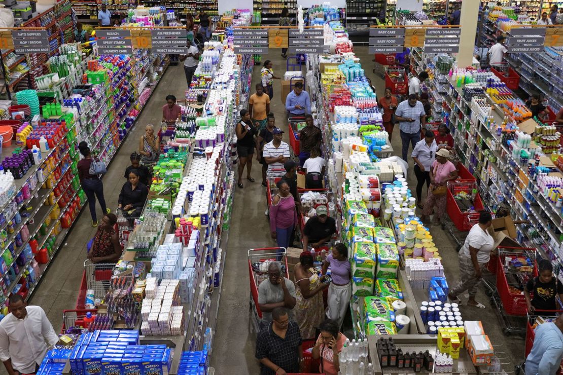 La gente en Kingston, Jamaica, espera en fila con alimentos mientras Beryl se acercaba el 1 de julio. Crédito: Gilbert Bellamy/Reuters.