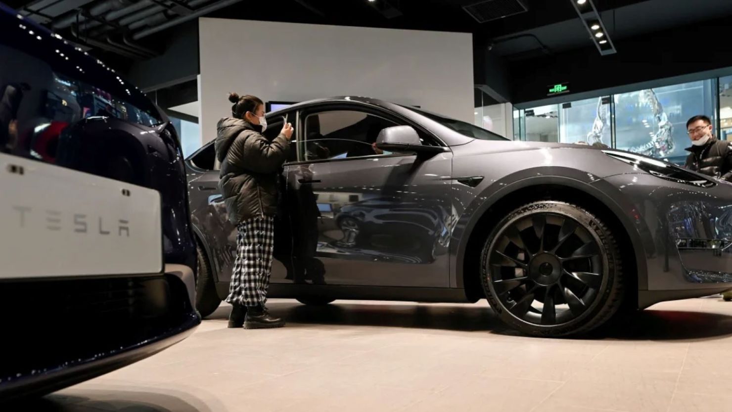 Un grupo de personas observa un Tesla Model Y en una sala de exposiciones de Tesla en Pekín, China, el 5 de enero de 2021. Wang