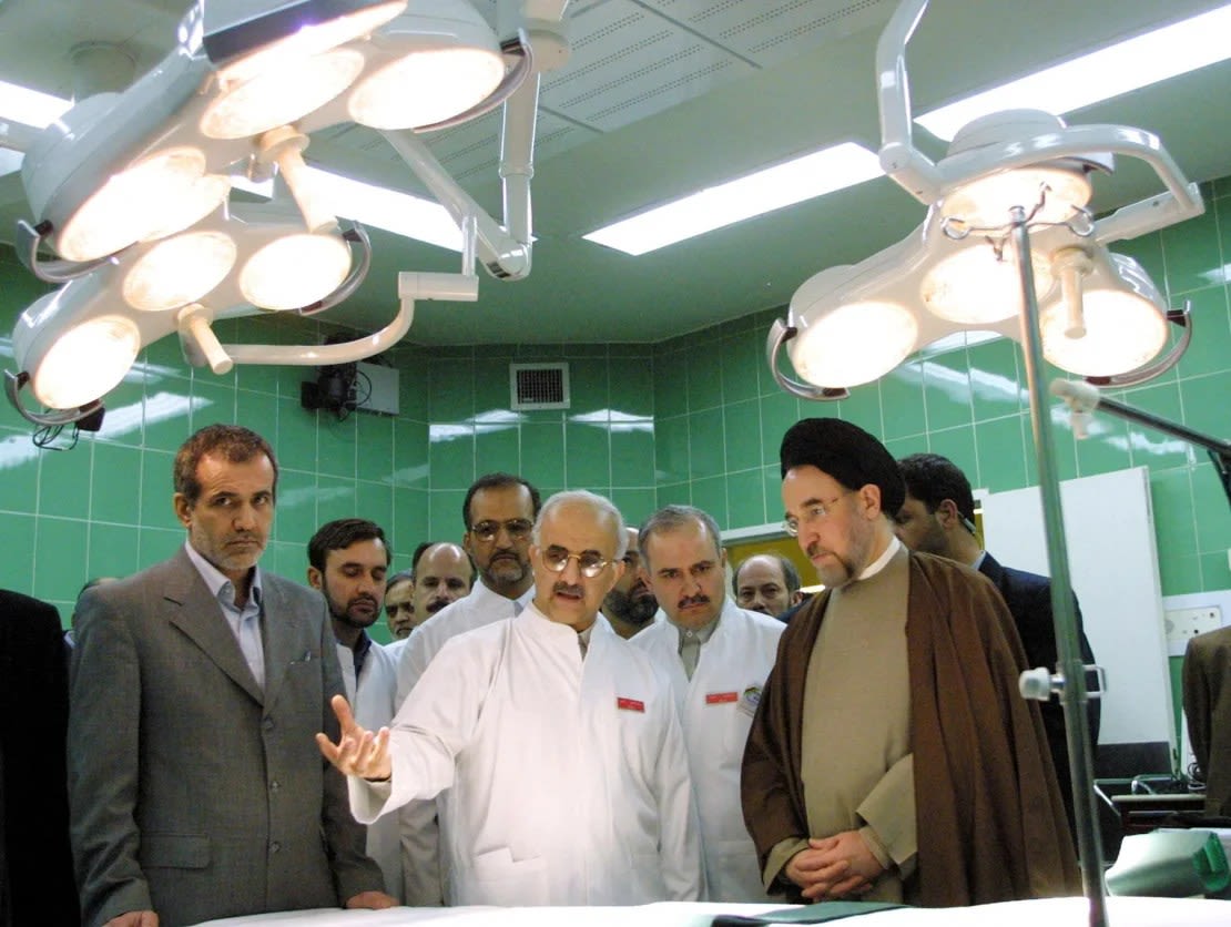 En esta fotografía de archivo de 2002, el entonces ministro de Salud Masoud Pezeshkian, izquierda, y el entonces presidente iraní Mohammad Khatami, derecha, escuchan a Abbas-Ali Karimi, centro, jefe del Centro de Cardiología de Teherán, mientras visitan un quirófano durante la inauguración del centro.