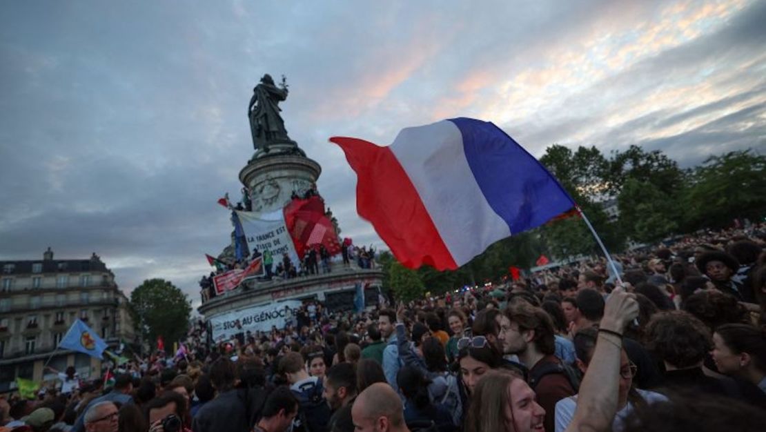 Una persona ondea una bandera francesa durante un mitin en la Place de la République.