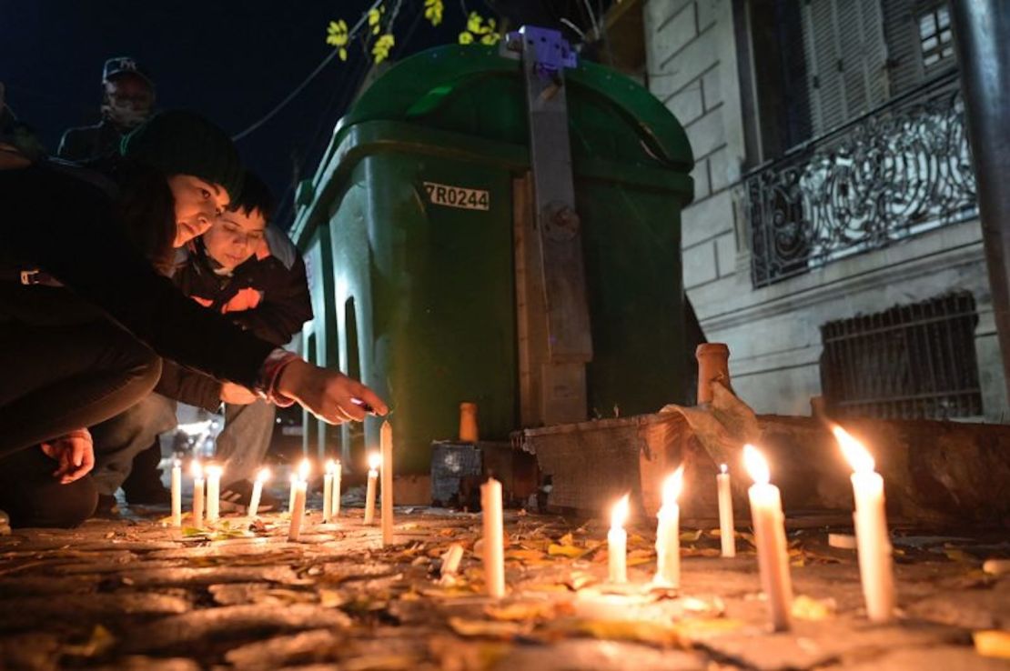 Mujeres encienden velas durante una vigilia el 8 de mayo de 2024, frente a la pensión donde tres lesbianas fueron asesinadas en Buenos Aires.