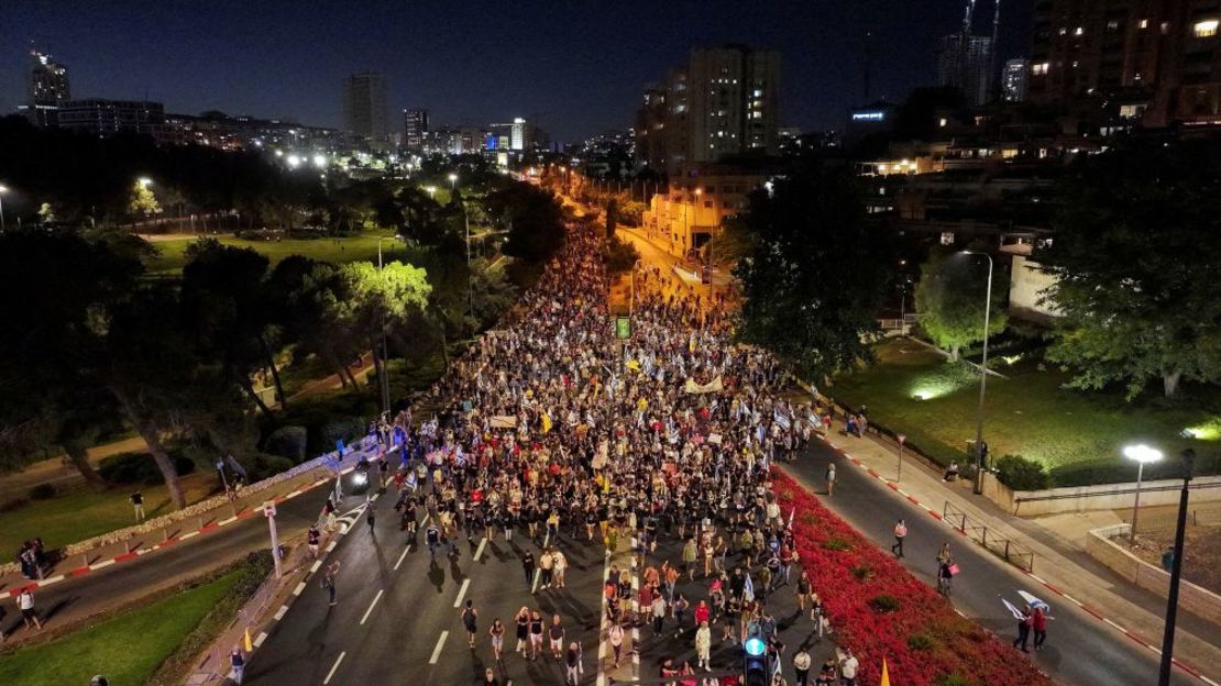 Personas marchan por la calle mientras manifestantes antigubernamentales conmemoran los nueve meses desde el mortal ataque del 7 de octubre, bajo el lema "Israel se paraliza", frente a la residencia privada del primer ministro de Israel, Benjamin Netanyahu, el domingo en Jerusalén. Crédito: Ilan Rosenberg/Reuters