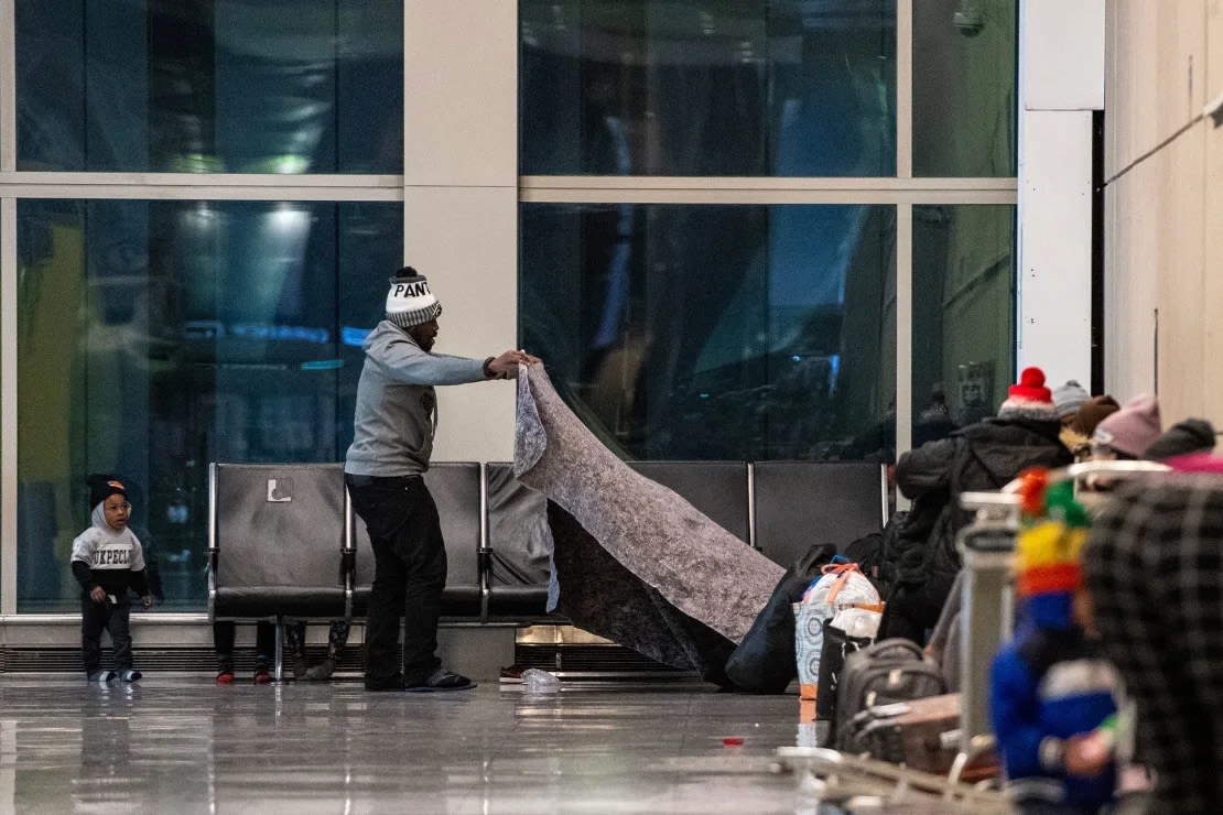 Esta fotografía de archivo de enero muestra a familias de inmigrantes utilizando la Terminal E del Aeropuerto Internacional Logan de Boston como refugio. Crédito: José Prezioso/AFP/Getty Images