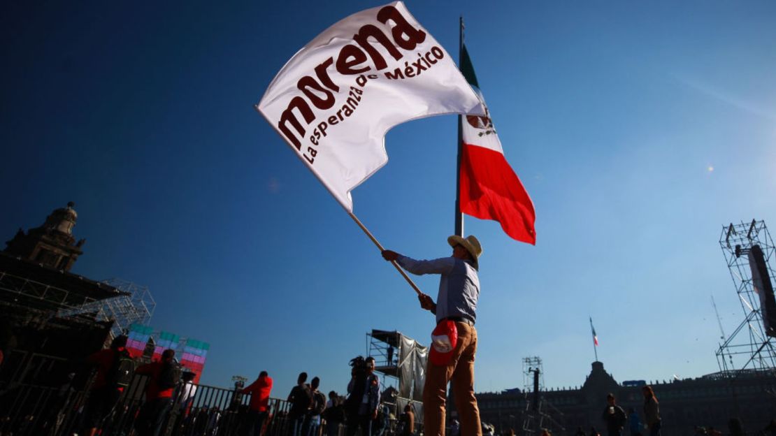 Un hombre ondea una bandera del partido Morena previo a los eventos de investidura presidencial en el Zócalo de la Ciudad de México el 1 de diciembre de 2018.