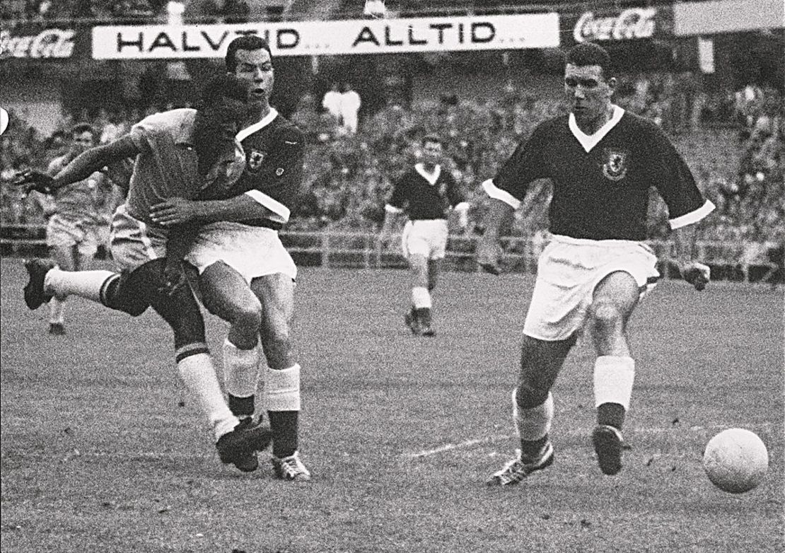 El delantero brasileño Pelé de 17 años, patea el balón entre dos defensores galeses durante el partido de fútbol de cuartos de final de la Copa del Mundo entre Brasil y Gales el 19 de junio de 1958 en Gotemburgo. Crédito: STAFF/AFP vía Getty Images