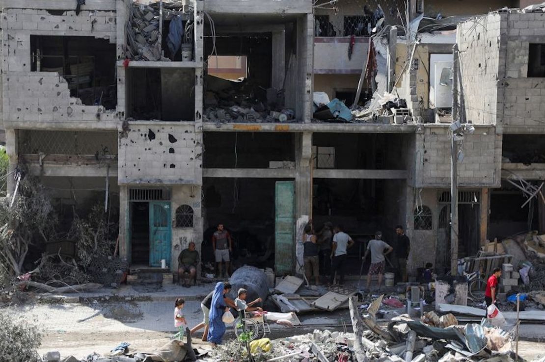 Varias personas caminan entre los escombros tras los ataques israelíes en la zona donde fueron rescatados los rehenes, en el campo de refugiados de Nuseirat, en el centro de Gaza, 9 de junio de 2024.