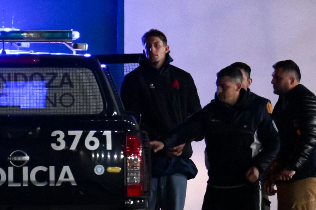 El jugador de la selección francesa de rugby Oscar Jegou (d) es escoltado por la Policía Federal Argentina a su llegada a la Estación Transitoria de Detenidos y Aprehendidos en Mendoza, Argentina, el 11 de julio de 2024.