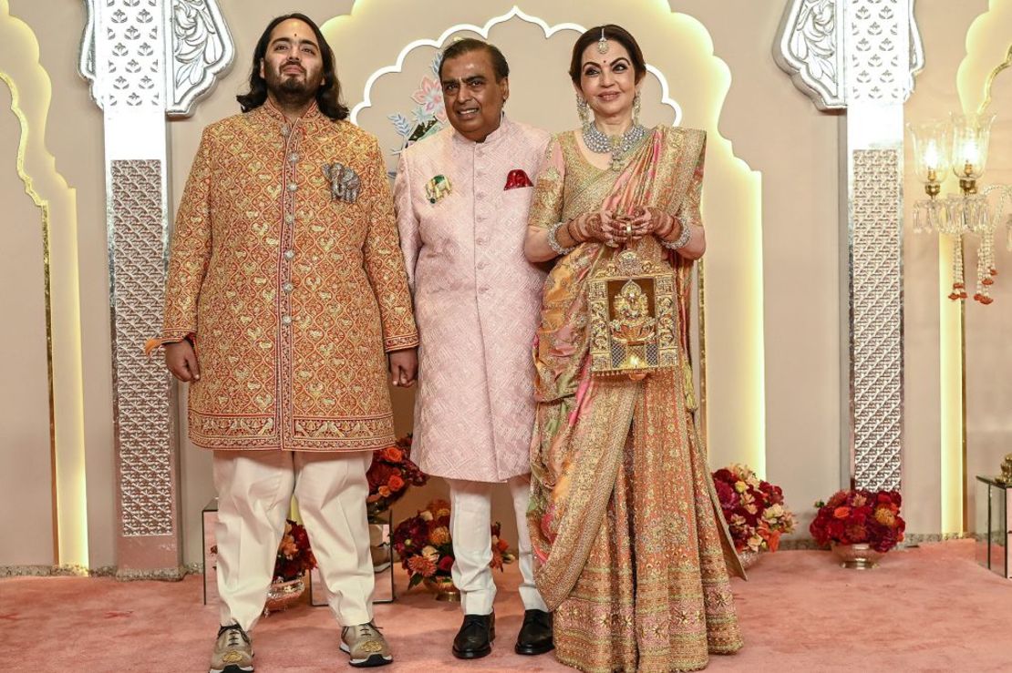 De izquierda a derecha, Anat Ambani junto a su padre Mukesh Ambani y su madre Nita, cuyo vestido tardó 40 días en ser confeccionado a mano por artesanos. Crédito: Sujit Jaiswal/AFP/Getty Images