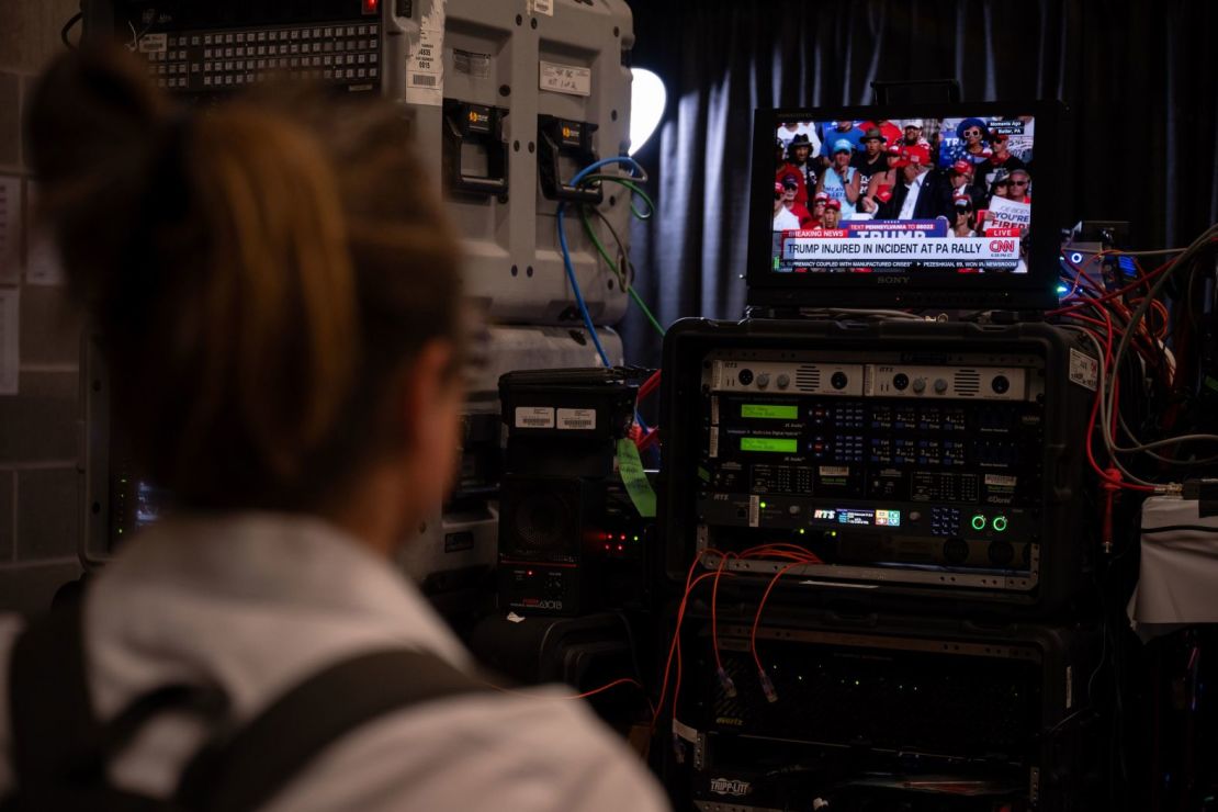 Un miembro de los medios de comunicación en el Foro Fiserv en Milwaukee mira un informe de noticias sobre el incidente de Trump. Will Lanzoni/CNN