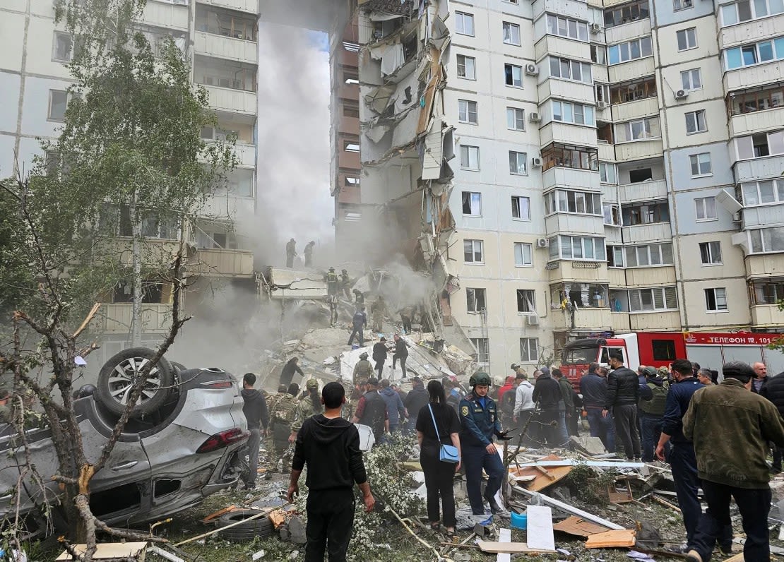 Varias personas se reúnen tras el derrumbe de una sección de un bloque de apartamentos de varios pisos en la ciudad de Belgorod, Rusia, el 12 de mayo de 2024.