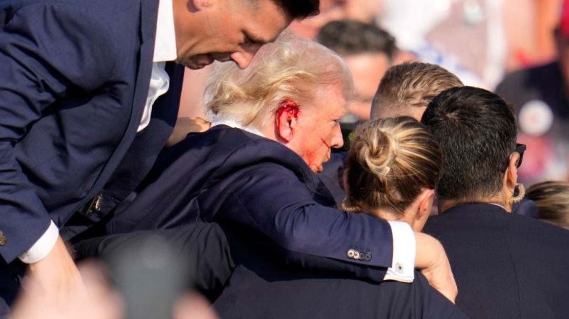 Ayudan al expresidente Donald Trump a bajar del escenario en un acto de campaña en Butler, Pensilvania, el 13 de julio de 2024. Crédito: Gene J. Puskar/AP