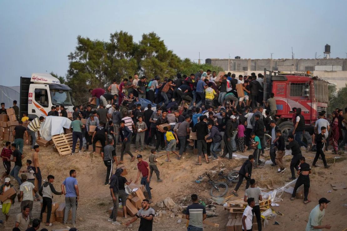 Palestinos abordan camiones cargados de ayuda humanitaria traída a través de un nuevo muelle construido por Estados Unidos en el centro de Gaza el 18 de mayo. Crédito: Abdel Kareem Hana/AP.