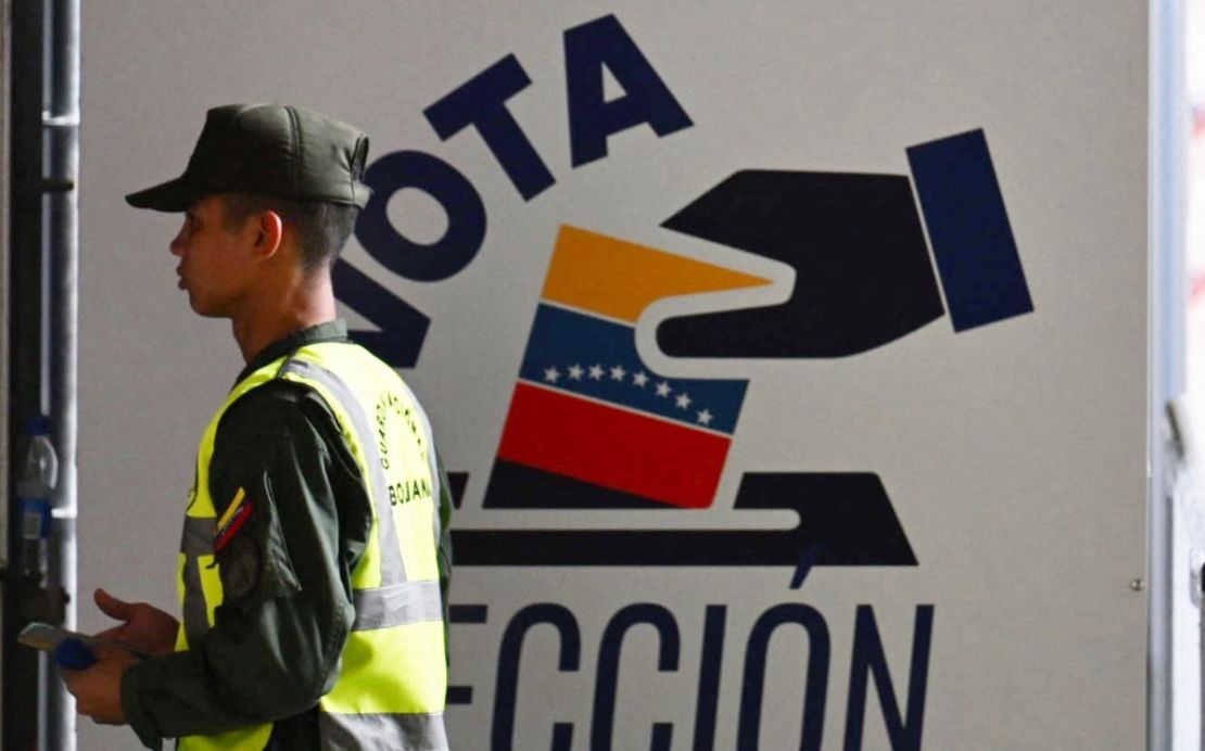 Un miembro de la Guardia Nacional pasa frente al centro de información del Consejo Nacional Electoral (CNE) en Caracas el 16 de julio de 2024. Venezuela celebrará elecciones presidenciales el 28 de julio.