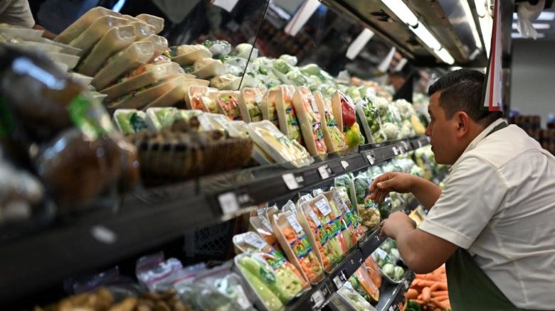 Un trabajador arregla frutas y verduras en un supermercado privado en San Salvador el 8 de julio de 2024.