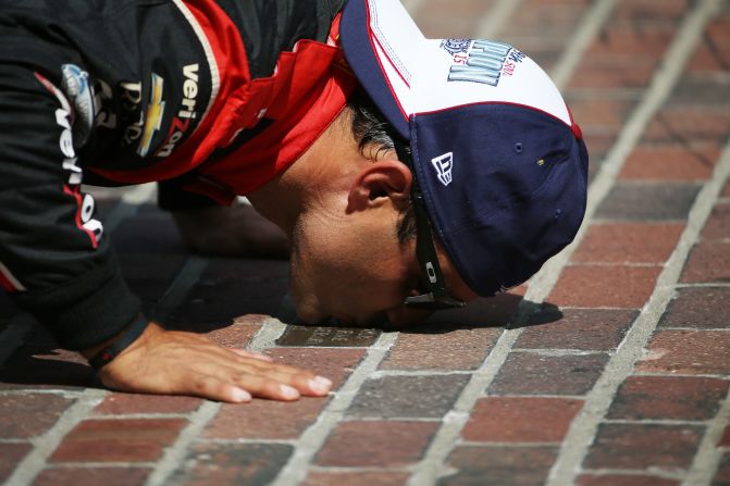 El piloto colombiano Juan Pablo Montoya besa el piso instantes después de ganar la edición 99 de las 500 Millas de Indianápolis.