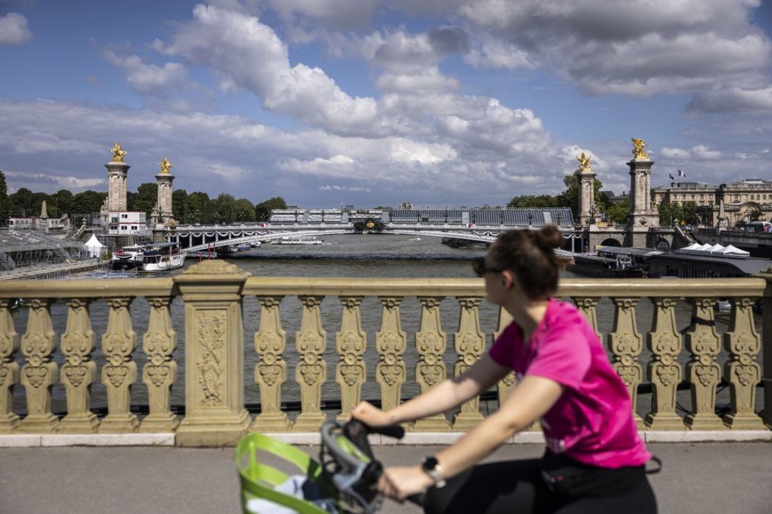 Una ciclista pasea por el puente Alexandre III, donde se han colocado filas de asientos para la ceremonia de apertura de los Juegos. Crédito: Olympia De Maismont/AFP/Getty Images